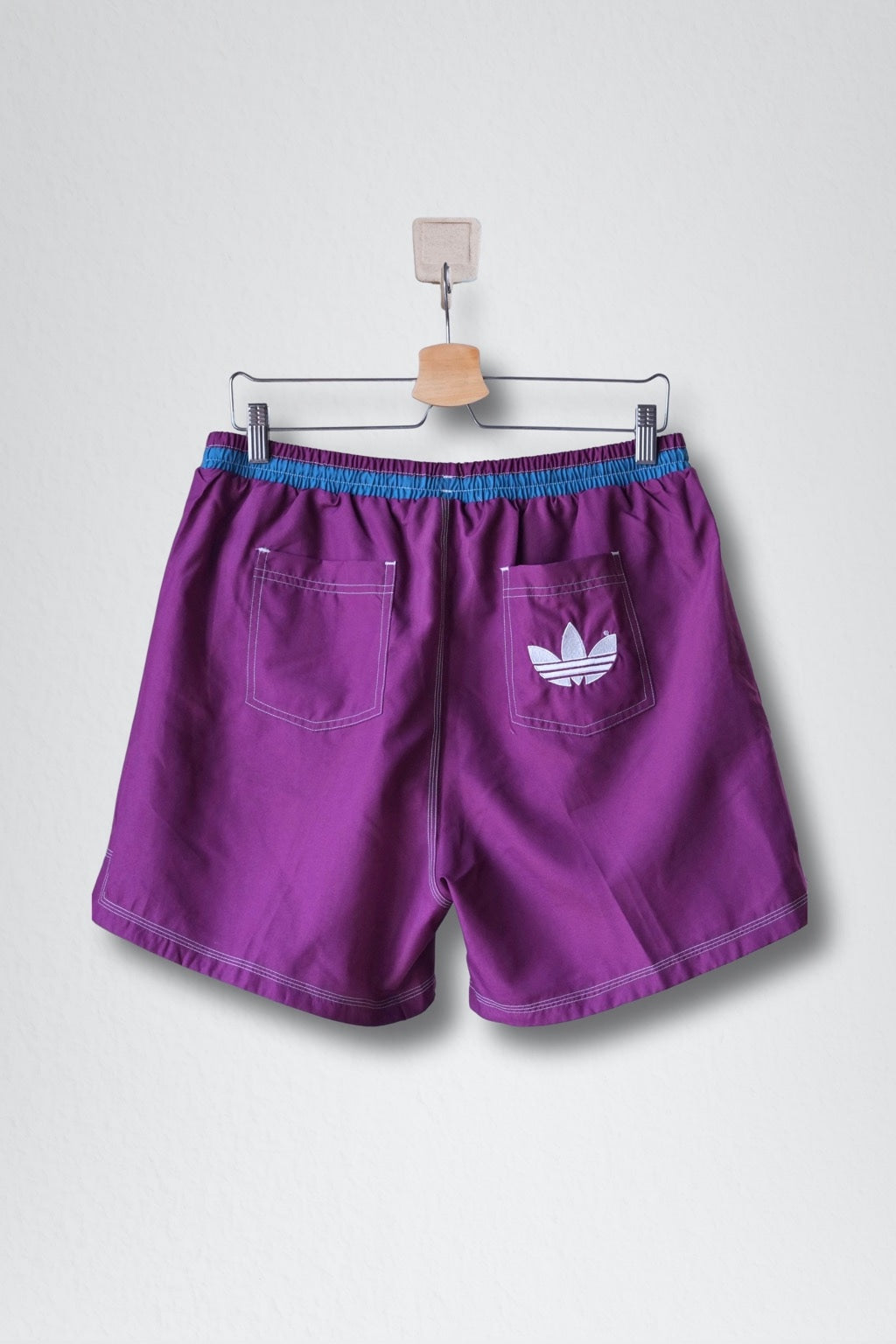 Back view of ADIDAS vintage 2000s two-tone swim shorts in blue and purple with drawstring waist and back Trefoil logo.