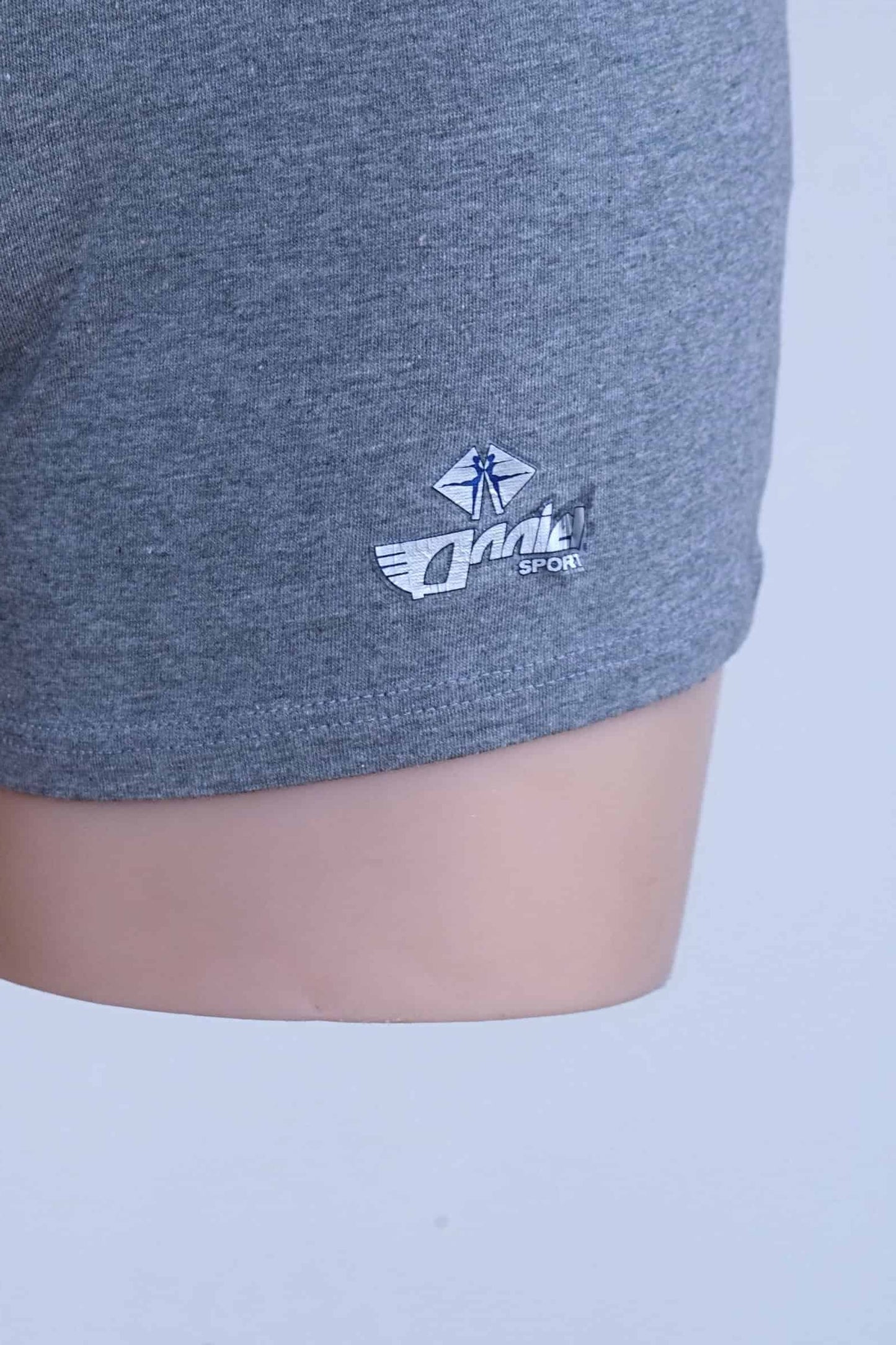 Close-up of worn Anniel Sport logo print on the leg of grey vintage romper.