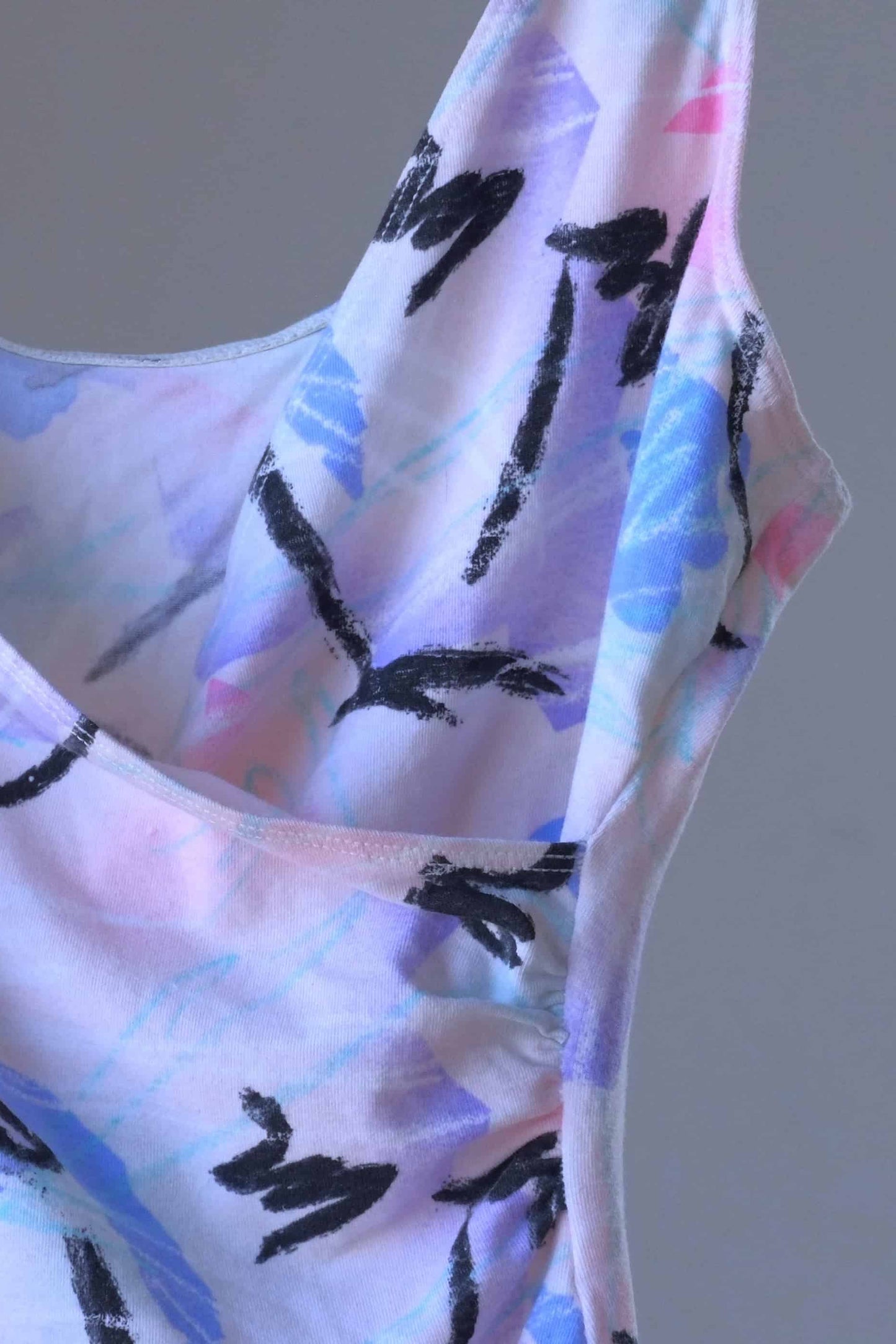 A close view of a vintage Danskin leotard with a pastel abstract print.