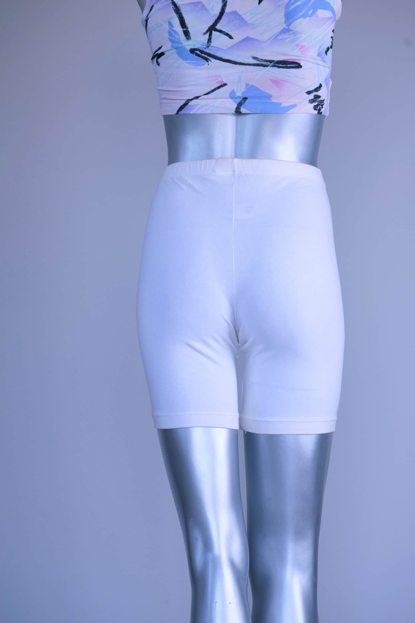 A pair of Vintage 90s white cotton biker shorts displayed on a silver mannequin, front view.