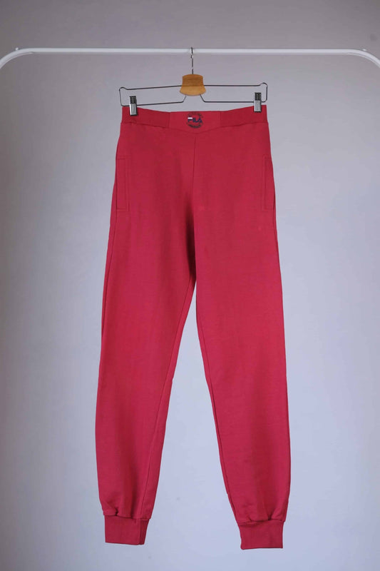 Red Fila 90s vintage jogging pants hanging on a hanger.