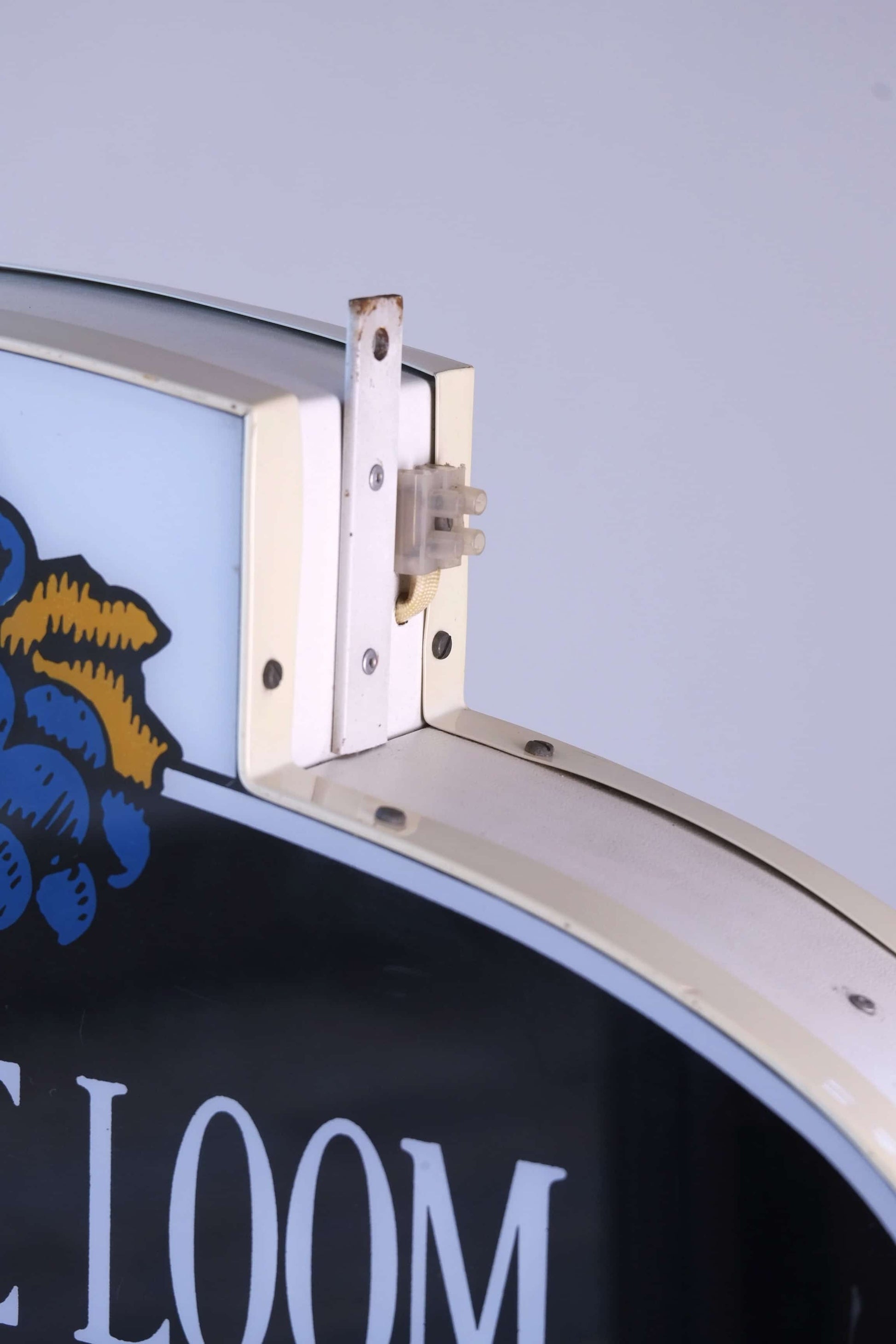 Close-up of top mounting bracket and electrical connector on vintage Fruit of the Loom hanging light sign.