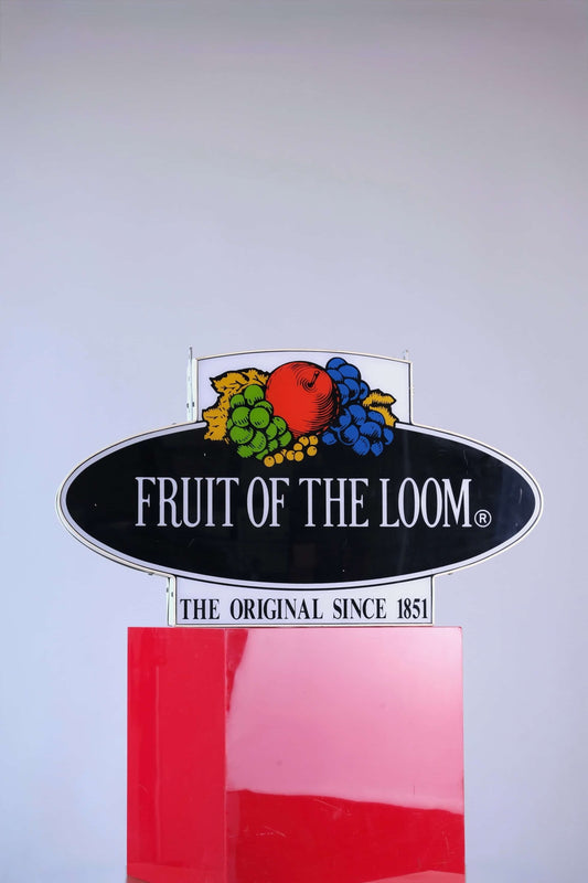 Vintage 90s Fruit of the Loom fluorescent neon-style sign, photographed head-on showing bright logo and black oval background.