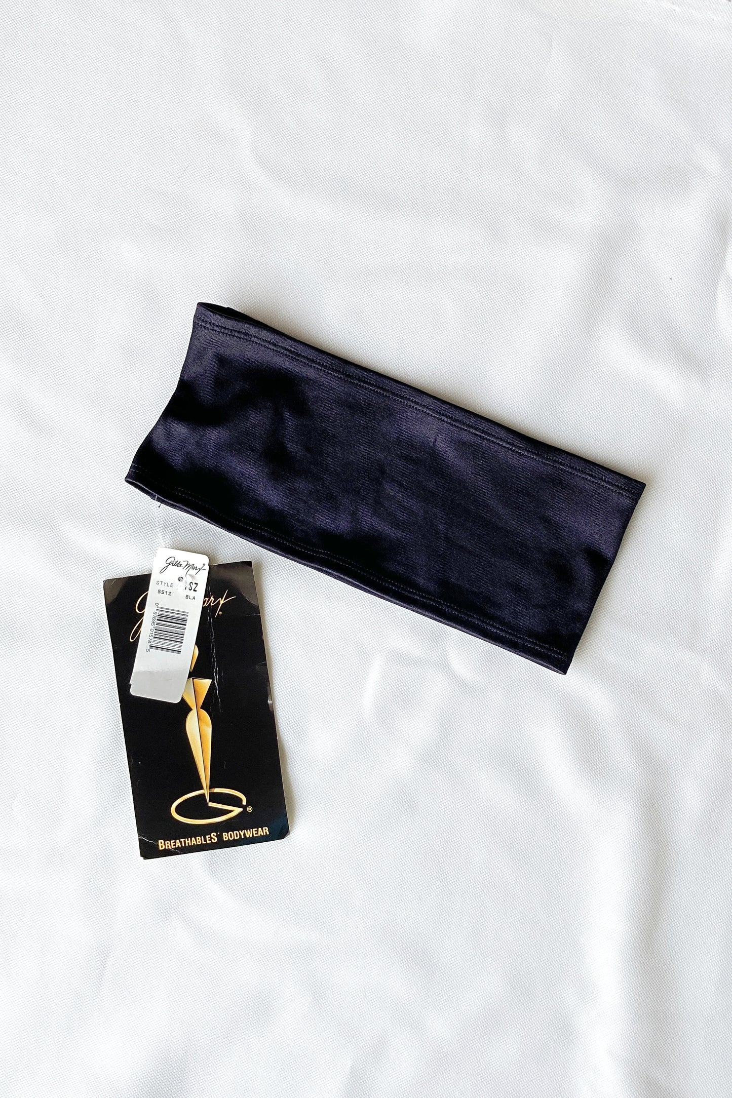 The black vintage Gilda Marx waistband, shown flat on a white surface with the original tag attached.