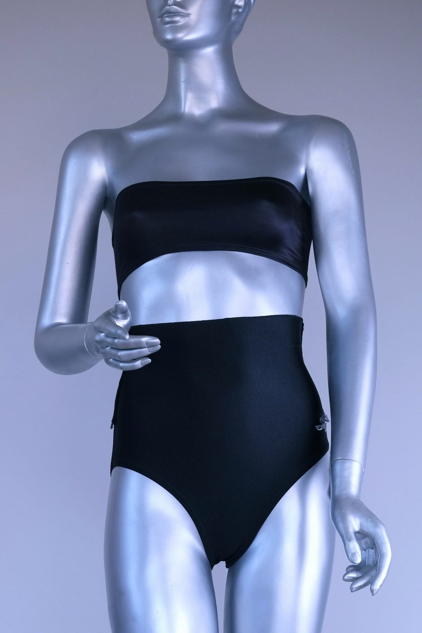 Silver mannequin wearing a black tube top bra and black dance briefs against a gray background
