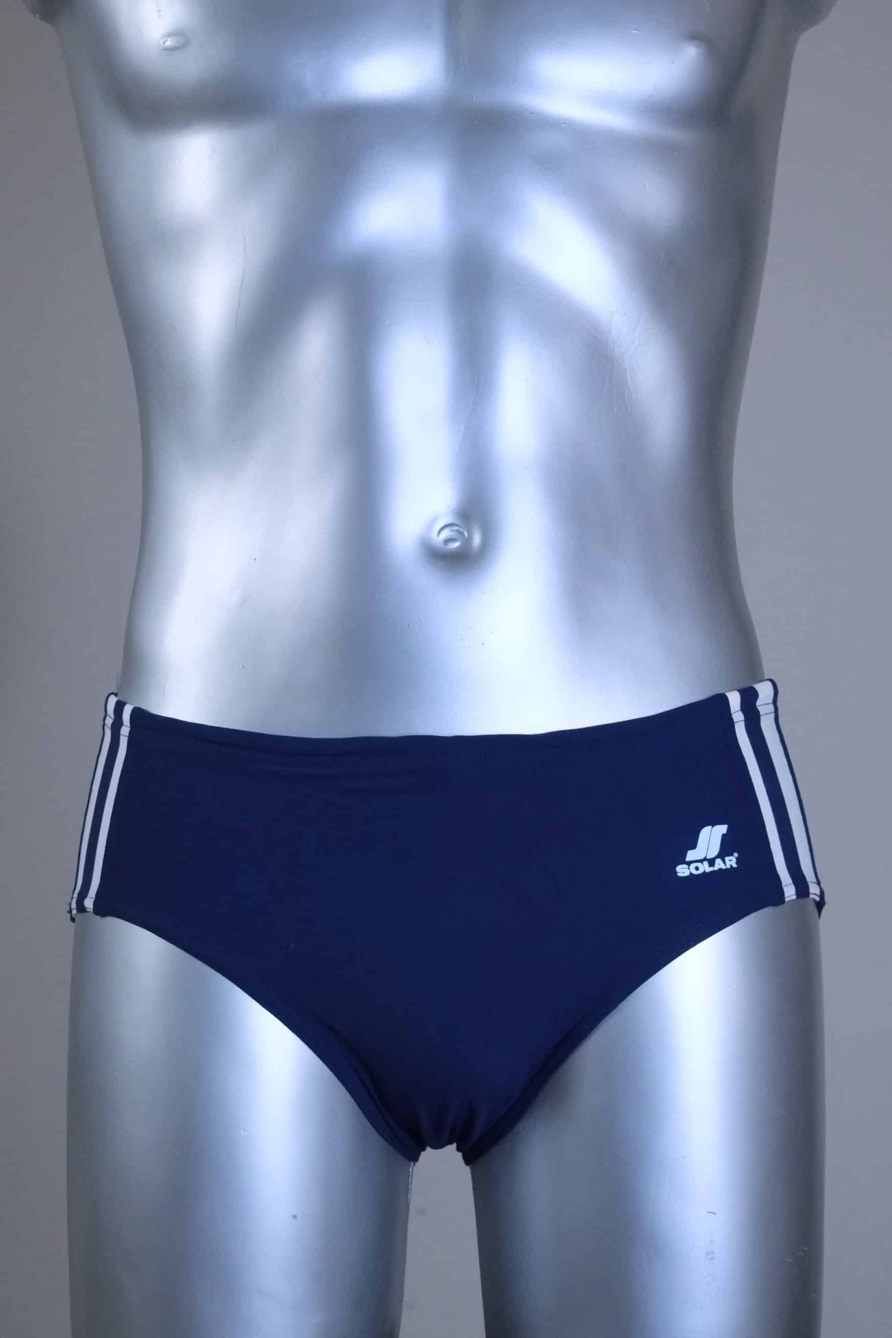 A pair of a Vintage navy men's swim briefs with white stripes on a metallic mannequin against a gray background