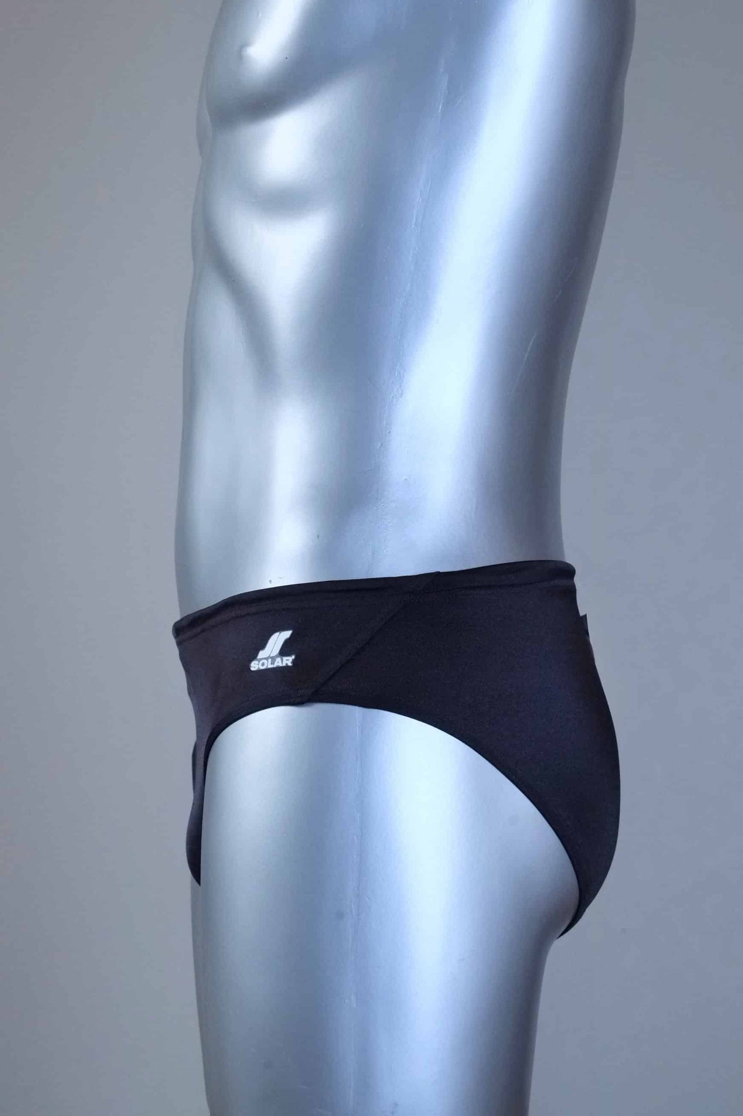 Side of a pair of SOLAR vintage 70s swim briefs in black shown on a silver mannequin