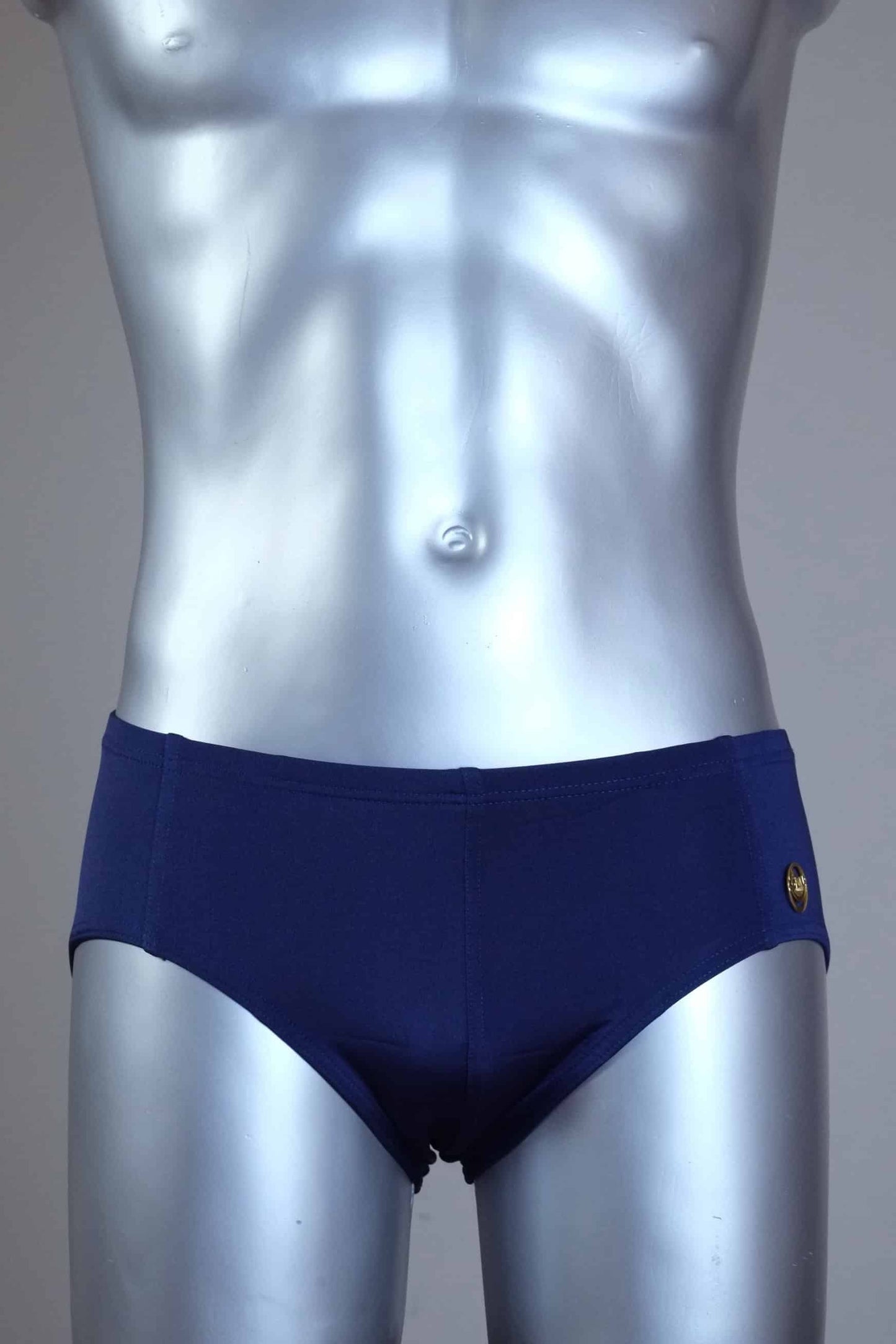 Mannequin wearing a pair of vintage 70s navy swim briefs with a visible brand logo on a gray background