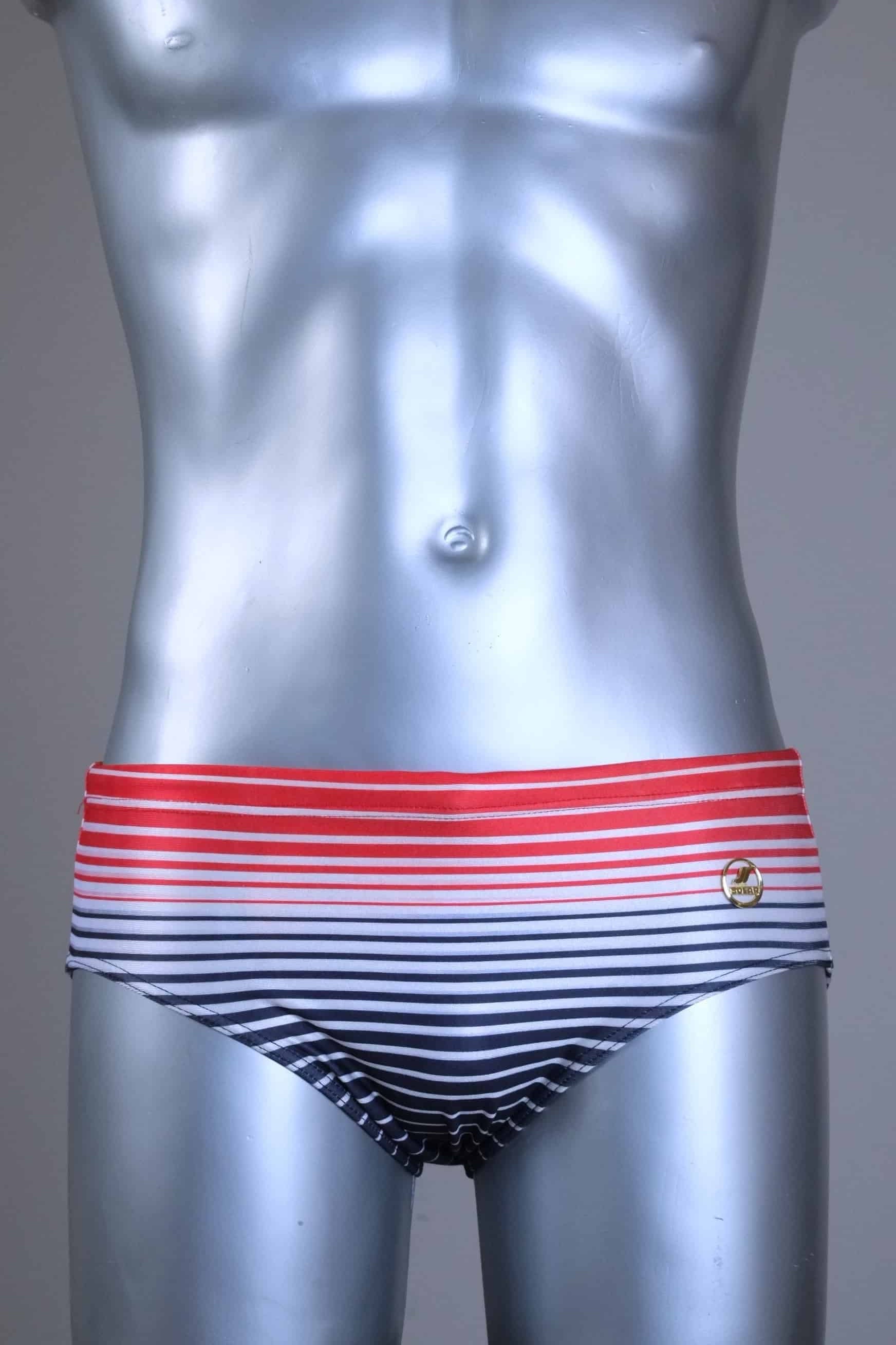 Vintage 80s men's swim briefs featuring a red-to-black gradient horizontal stripe pattern on a silver mannequin