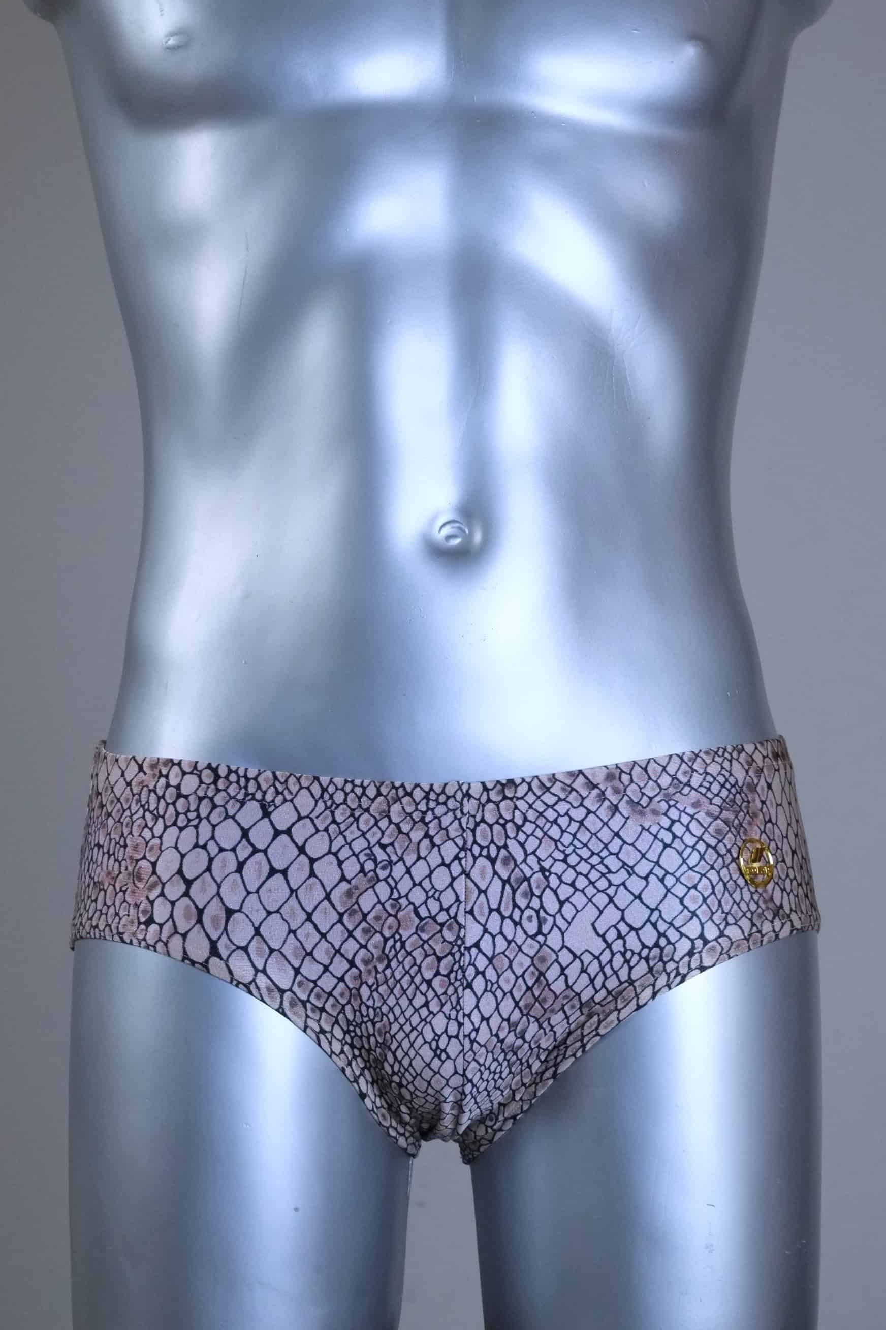 Vintage SOLAR swim briefs with light brown snakeskin print pattern, gold metal logo badge, displayed on mannequin.