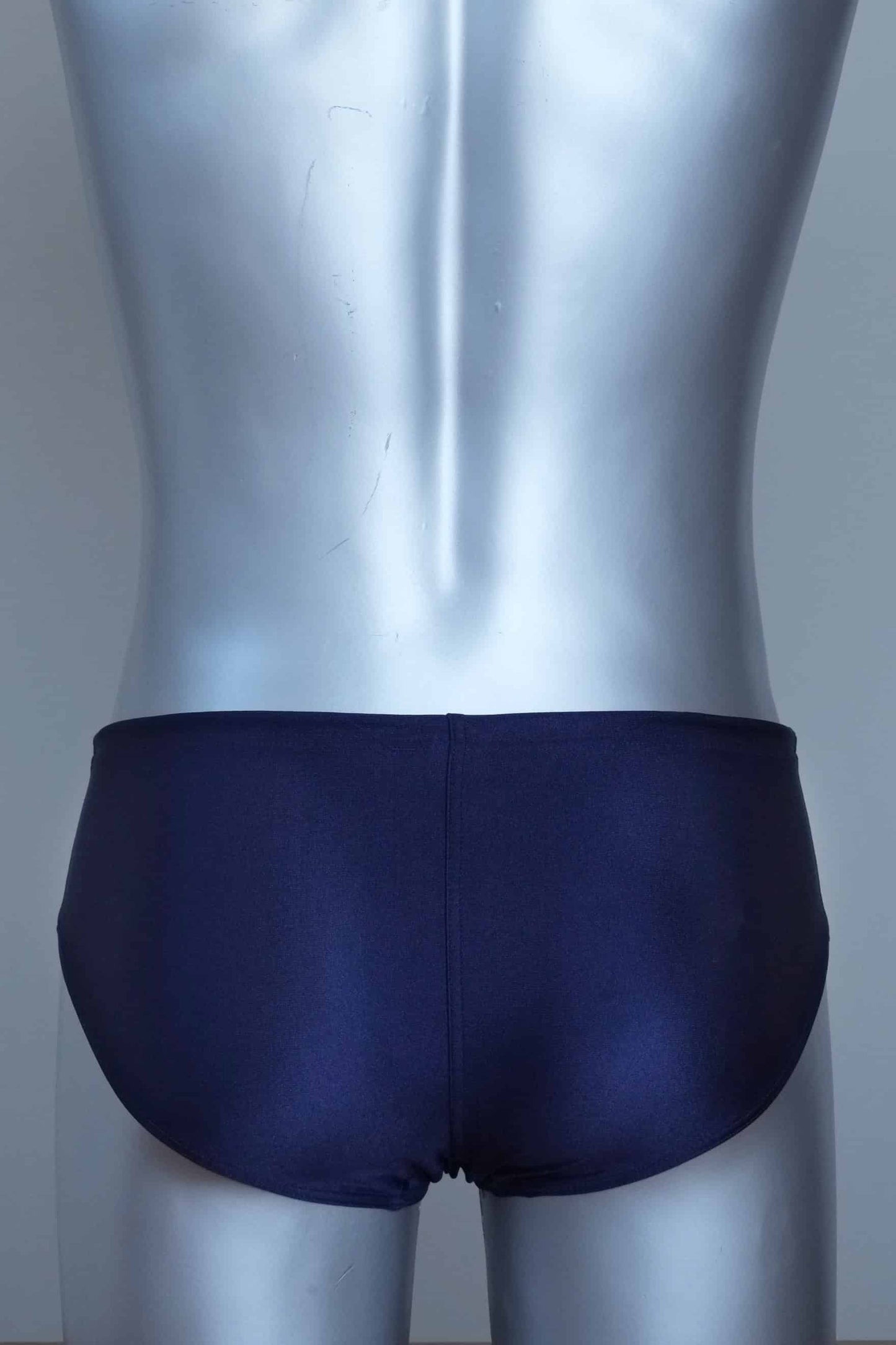 Back view of vintage navy swim briefs with mannequin against a gray background