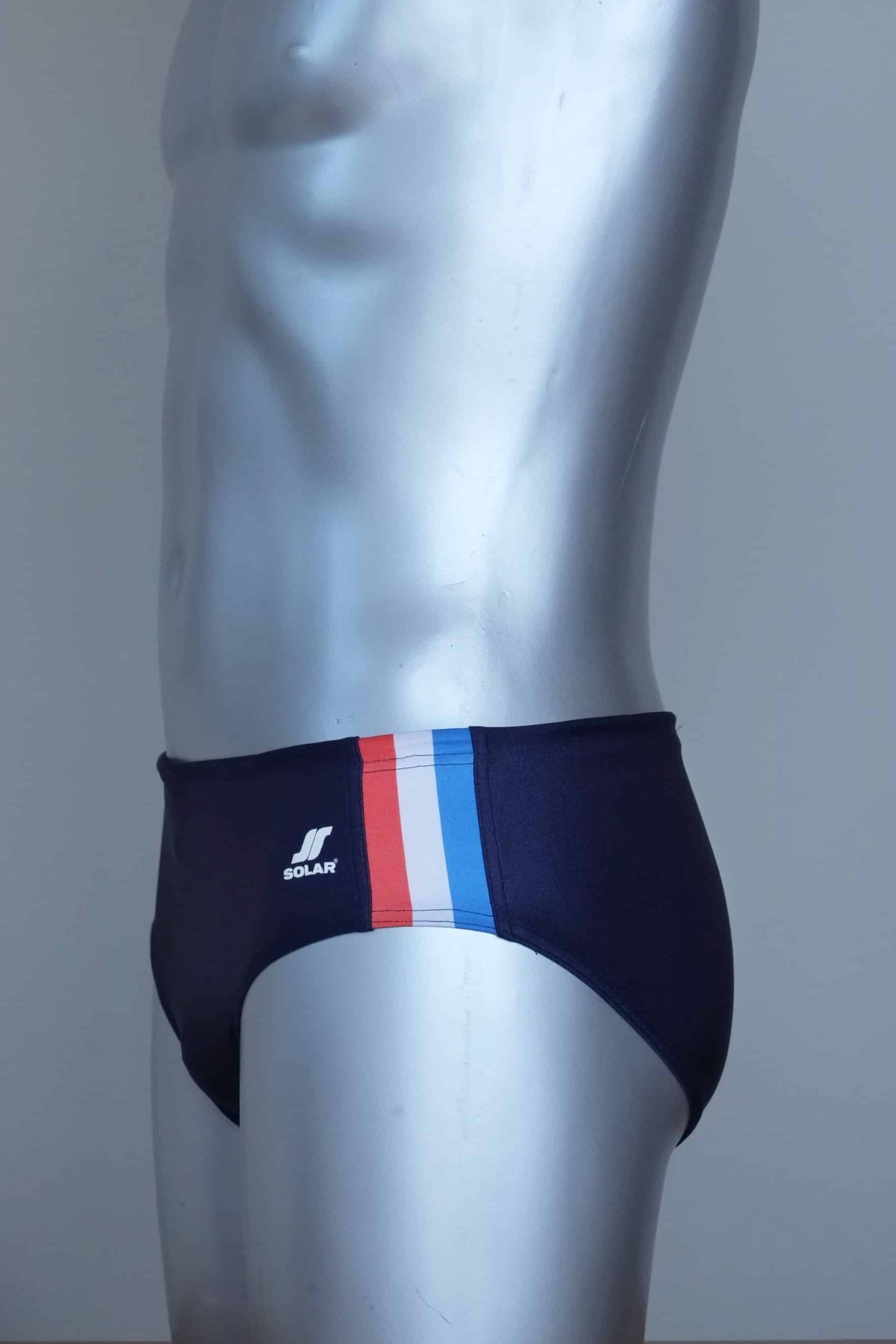 Side view of vintage navy swim briefs with colorful side band on a mannequin against a gray background
