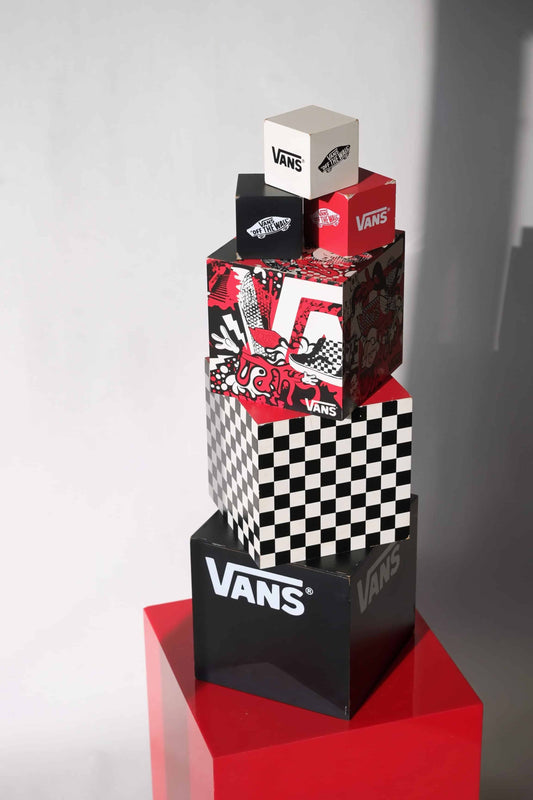 Vintage 2000s VANS dealer display cube set with nesting boxes, stacked in full view on a red pedestal, showing graffiti art, checkerboard, and branding.