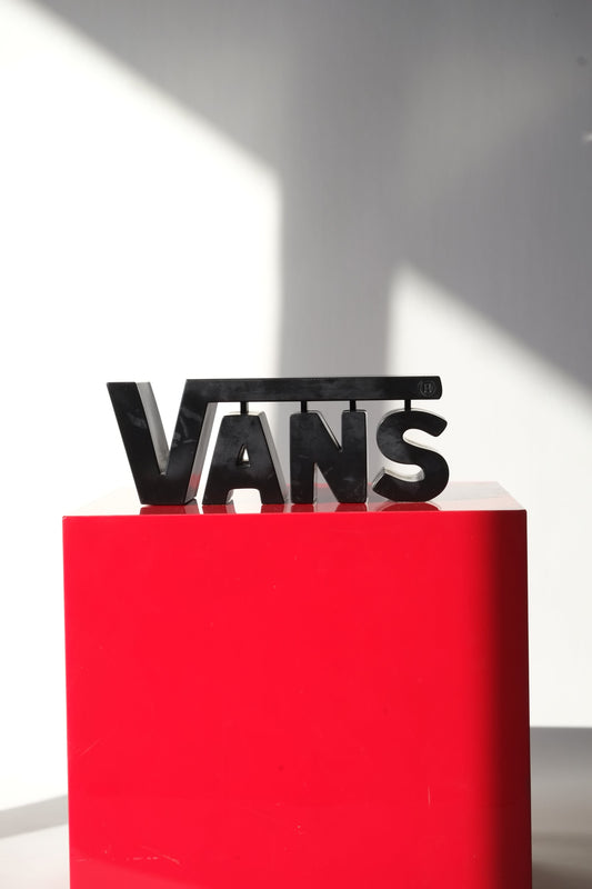 Clean front-facing shot of the vintage Vans 3D logo dealer sign styled on a glossy red cube under natural light.