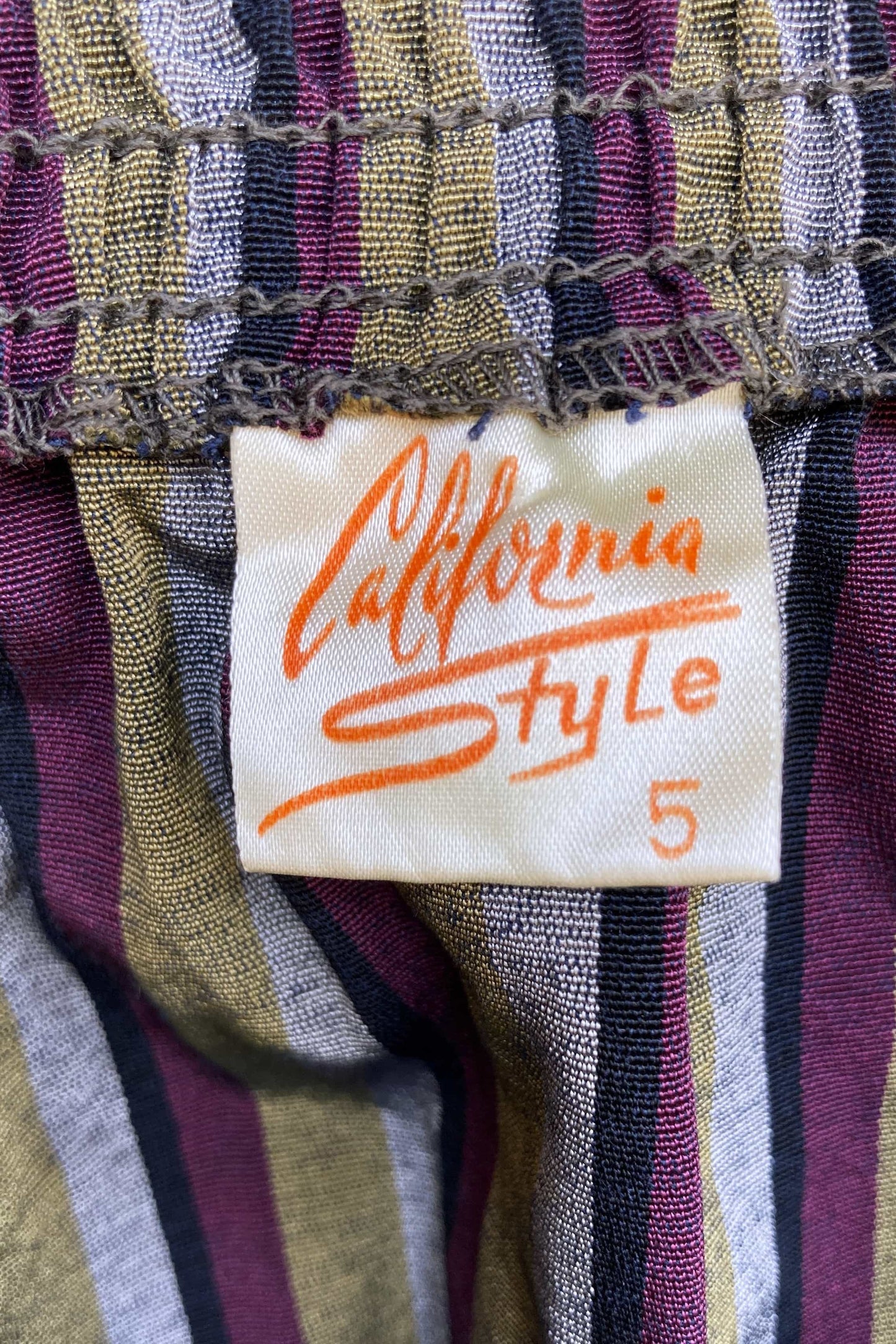 Close-up of a striped fabric with a brand label featuring the stylized text California Style.