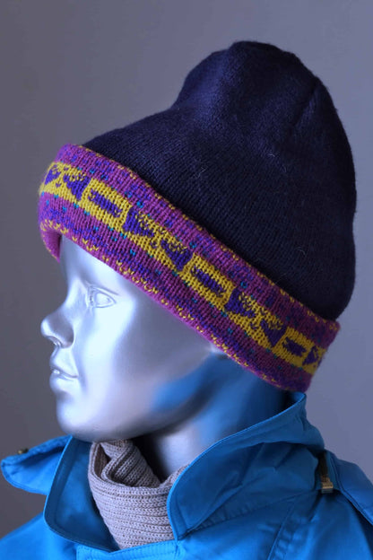 WOOL Kids Beanie in navy and a purple/yellow jacquard cuff on mannequi 