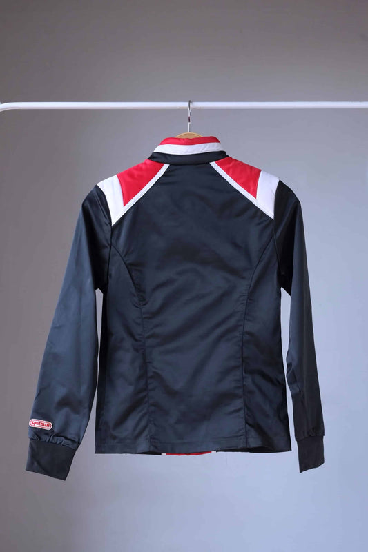 Back view of a vintage Sportalm ski jacket. The jacket is predominantly black with red and white stripes and a stand-up collar.