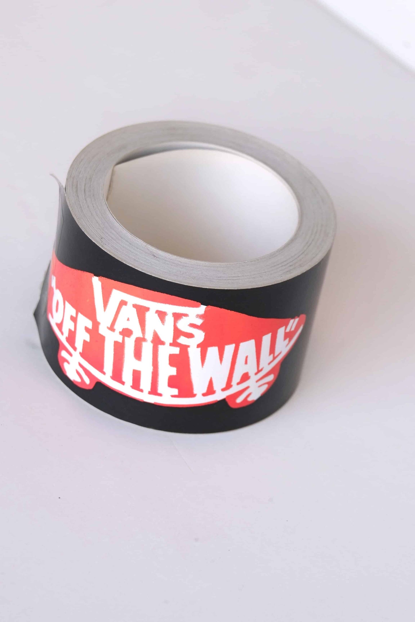 A roll of Vans Off The Wall logo adhesive tape, rare 2000s dealer promo with red skateboard logo against a white background.
