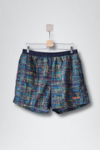 Front view of black ADIDAS vintage 2000s men's swim shorts with a multi-color abstract pattern. 