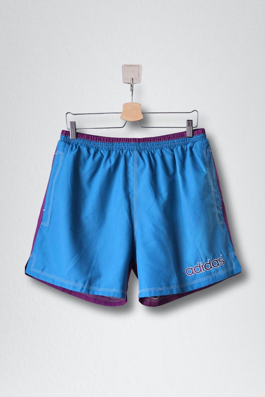 Front view of ADIDAS vintage 2000s two-tone swim shorts in blue and purple with drawstring waist and back Trefoil logo.