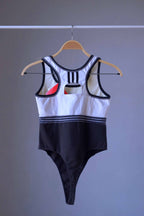 Back view of a vintage ADIDAS black and white thong-cut bodysuit with a racerback style.