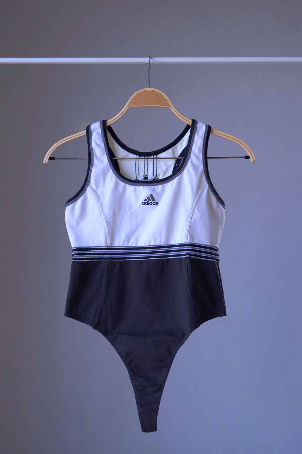 Front view of a vintage ADIDAS black and white thong-cut bodysuit with a racerback style.