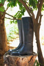 A pair of black AIGLE Saumur Horseback Riding Boots on tree trunk