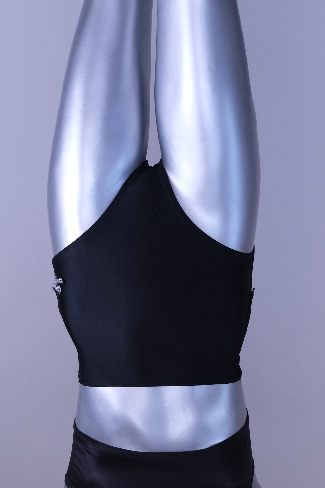 A pair of black, high-rise dance briefs with a folded-over waistband and a logo on the left hip, displayed on a mannequin.