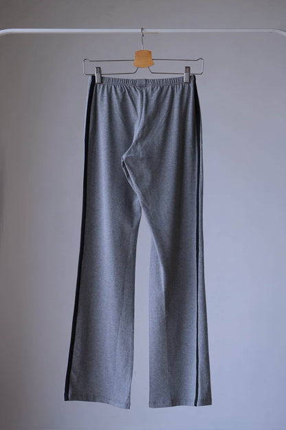 Back view of a pair of Anniel High-waisted, stretchy Charcoal gray flared leggings with black trim displayed on a hanger.