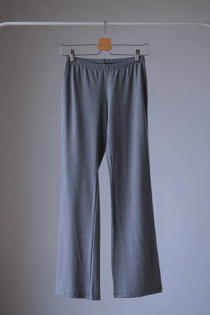 A pair of Anniel High-waisted, stretchy Charcoal gray flared leggings with black trim displayed on a hanger.