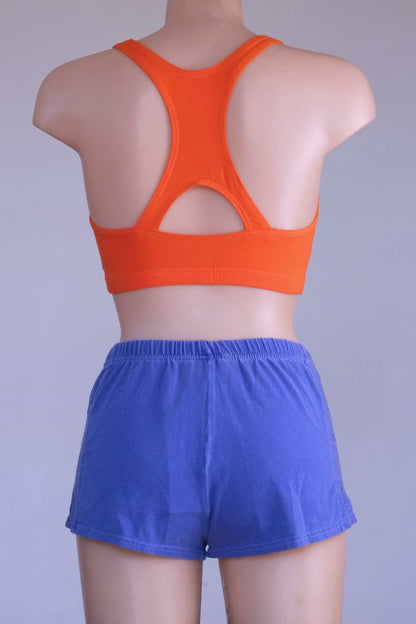 Back view of a mannequin wearing a Vintage 90s Anniel orange racerback sports bra and blue shorts, highlighting the keyhole detail.