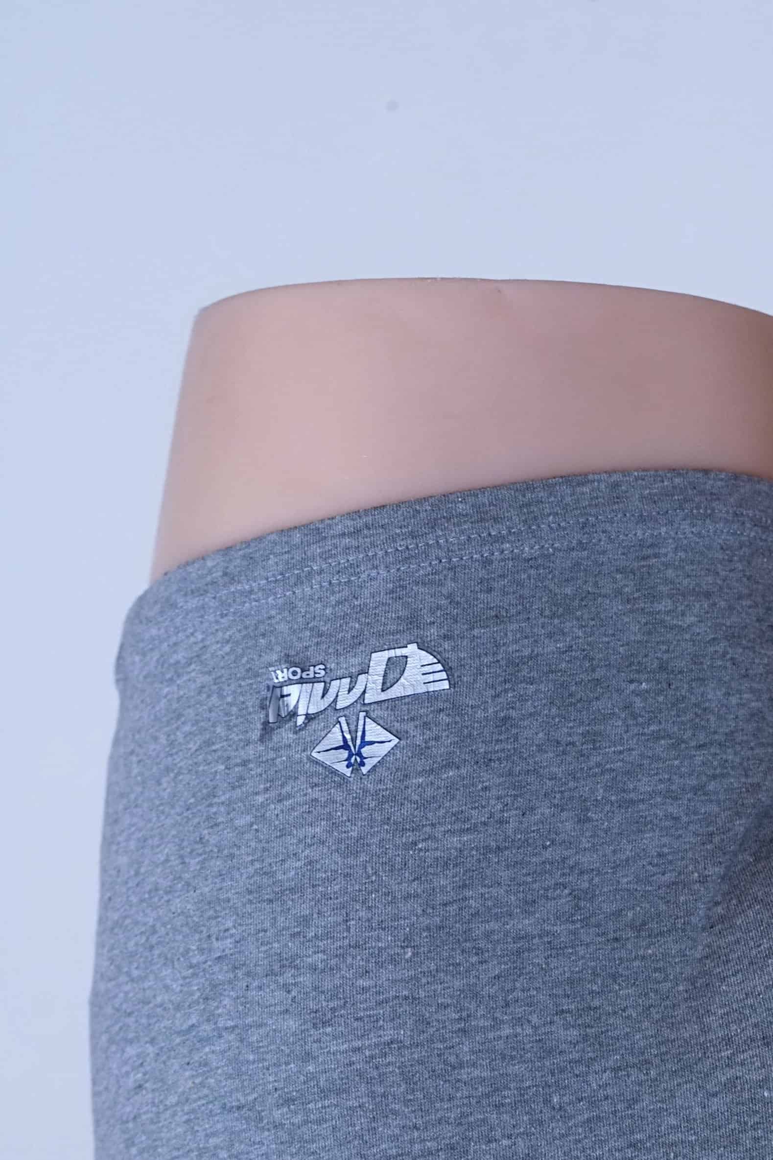 Close-up of worn Anniel Sport logo print on the leg of grey vintage romper.