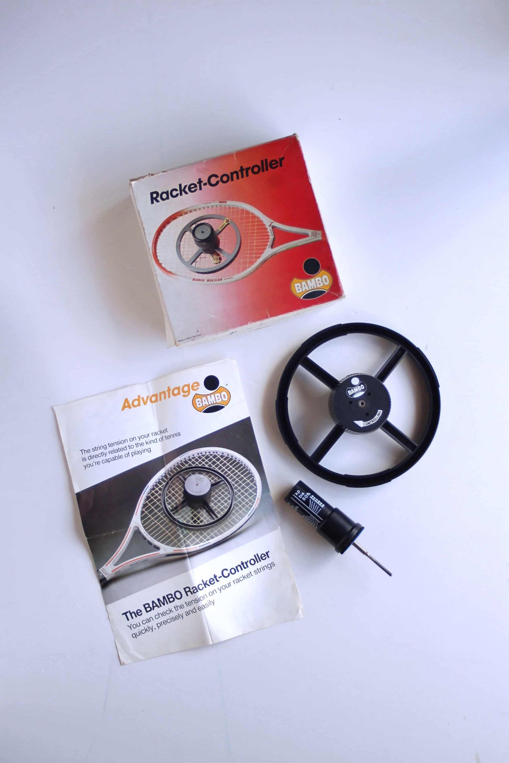 Full product set of the vintage deadstock BAMBO Racket-Controller tension tester, including the wheel unit, manual, tension gauge tool, and original box.