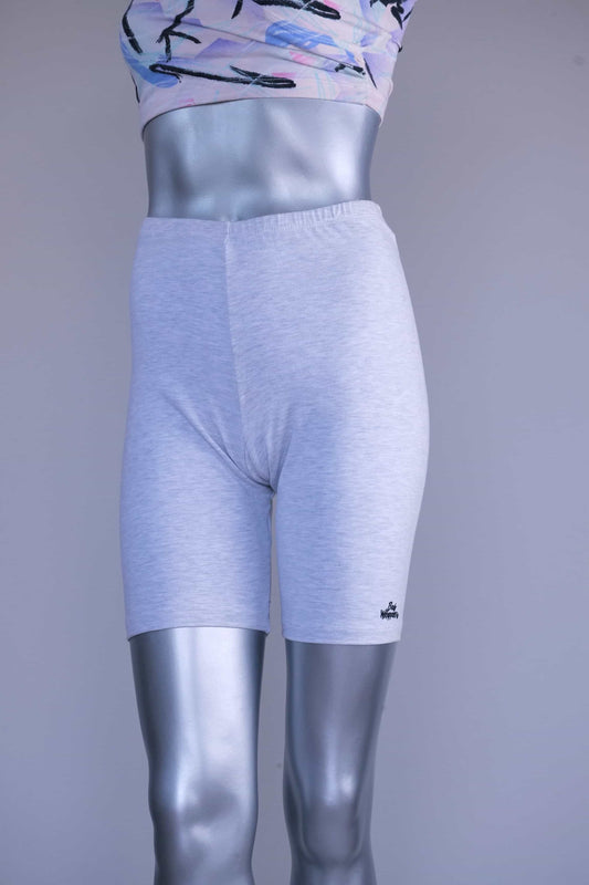 Front view of a mannequin wearing light ash gray vintage 90s BODY WRAPPERS bike shorts and a pastel print crop top, with a small logo on the lower leg.