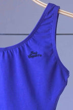 Close-up of the "Body Wrappers" logo printed on the front of the leotard.