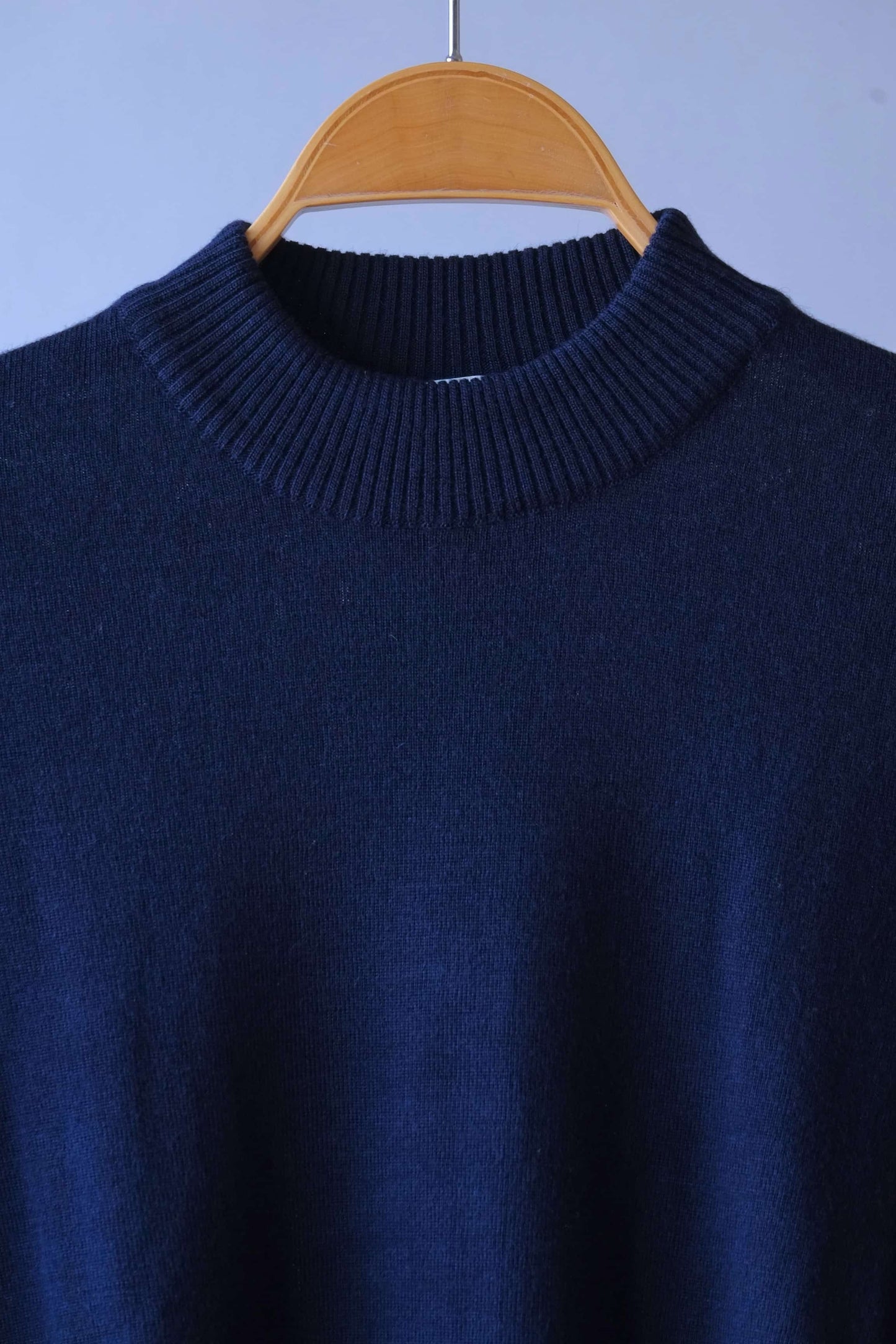 Detailed close-up of the ribbed high-neck collar on the navy vintage Cagi pure wool sweater.
