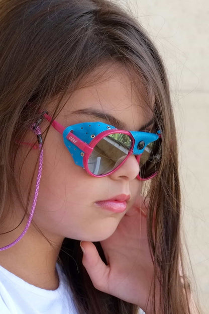 Pink and blue CÉBÉ Baby Glacier Sunglasses on girl model