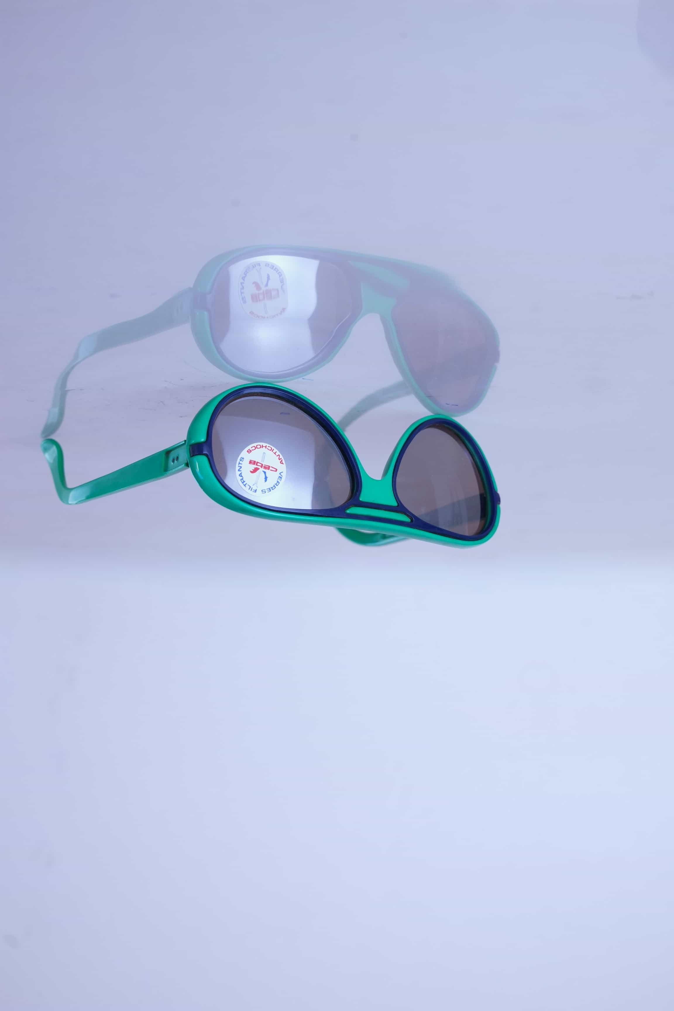 Three-quarter view of vintage Cébé aviator sunglasses in forest green with navy blue accents and original lens sticker.