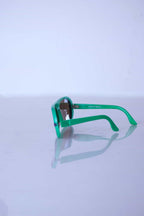 Side profile of green retro Cébé sunglasses showing the lightweight nylon frame construction and storage-related temple curve.