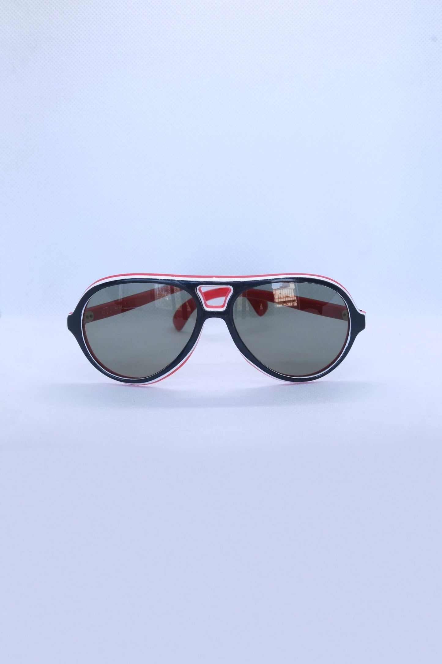front view of vintage cébé sunglasses dark navy and red on white background