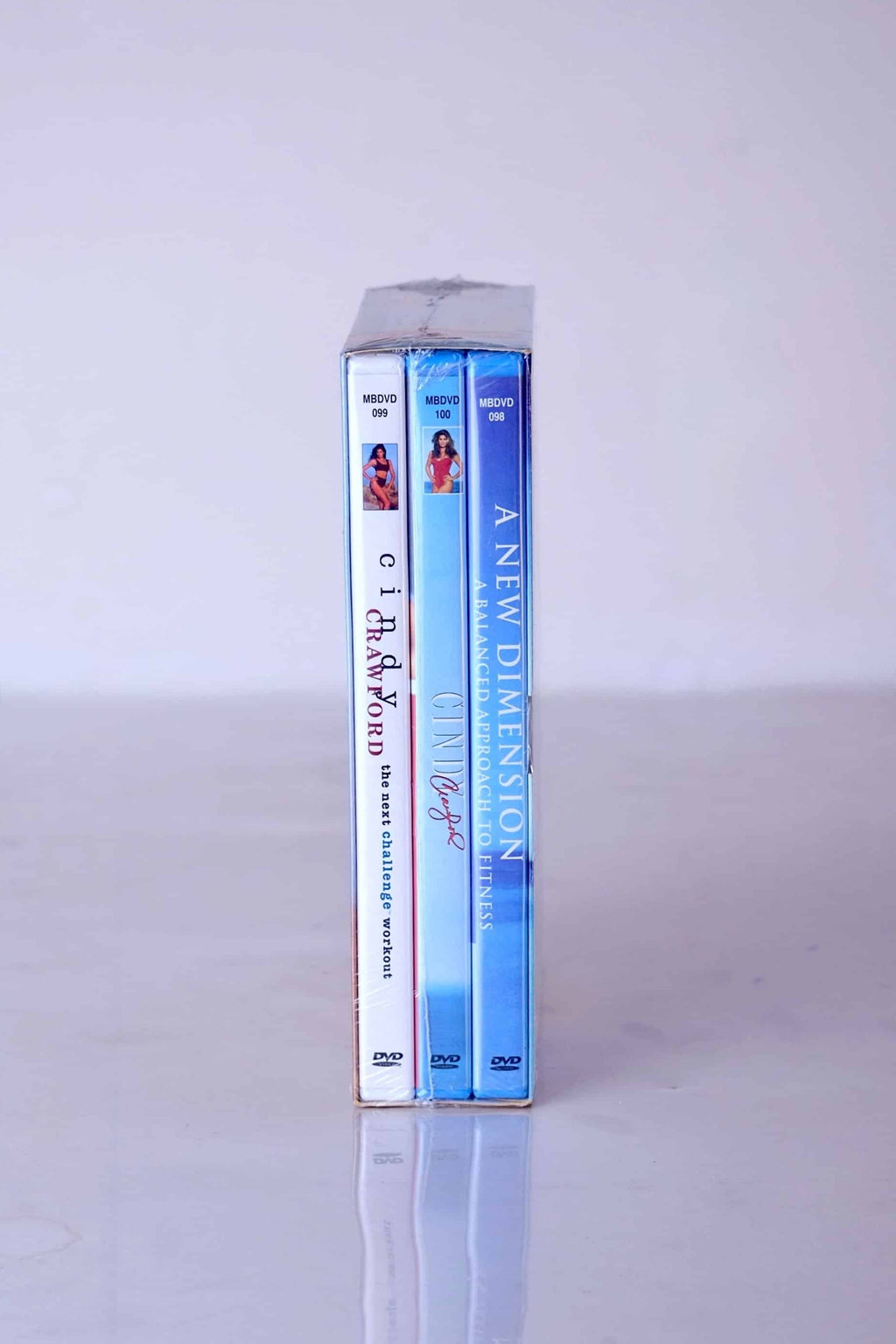 Side profile of the Cindy Crawford fitness DVD box set showing the three individual workout titles and 90s-era photography.