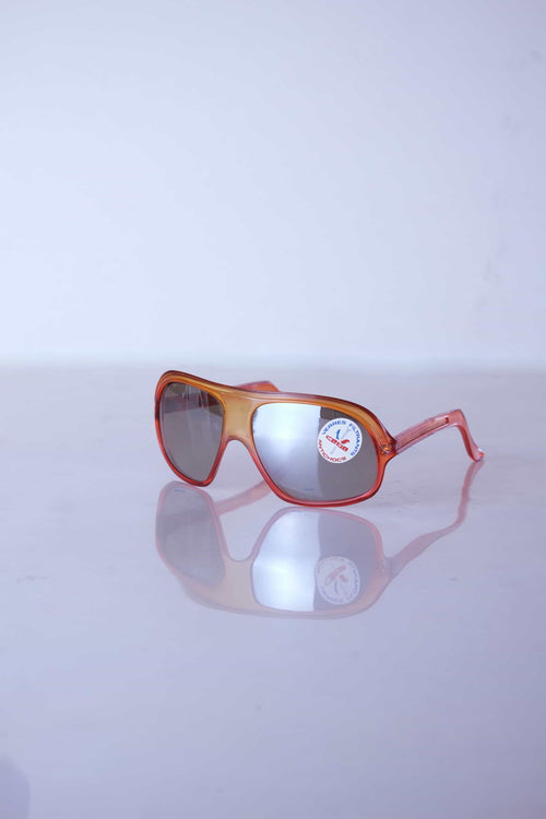 Angled perspective of vintage Cébé amber shield sunglasses showing the wrap-around design and reflective mirror lenses.