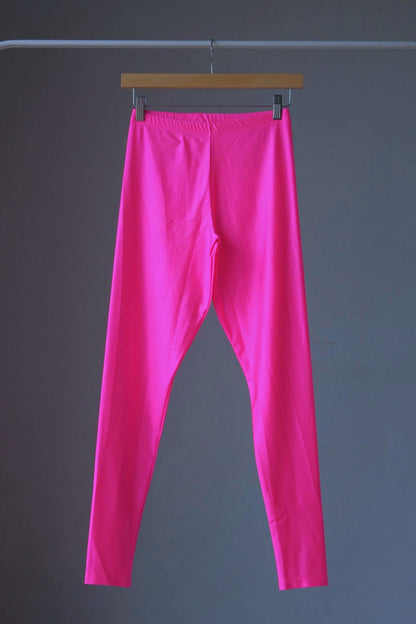 A pair of shiny neon pink vintage 90s Danskin high-waist leggings displayed on a hanger.
