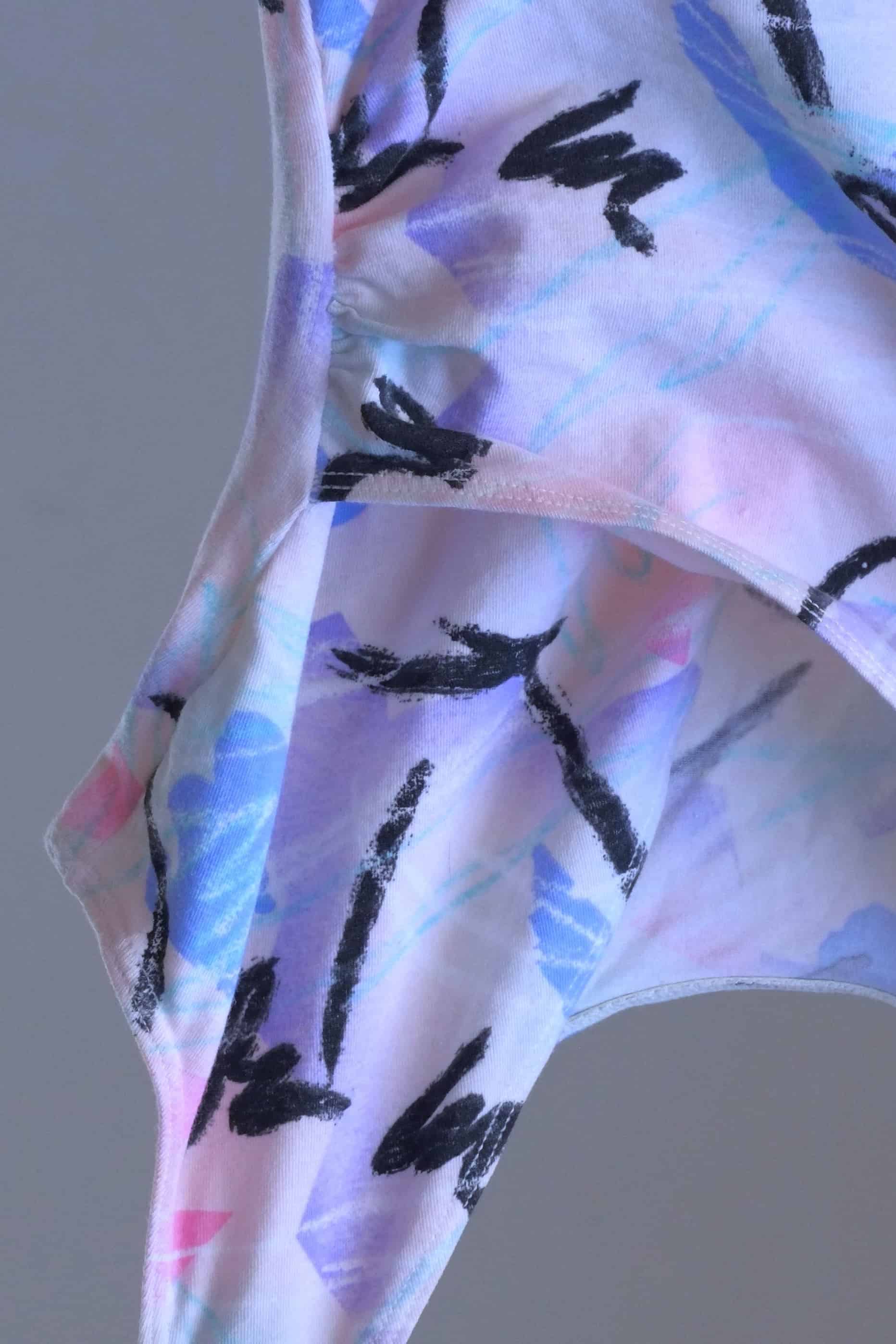 A close view of a vintage Danskin leotard with a pastel abstract print.