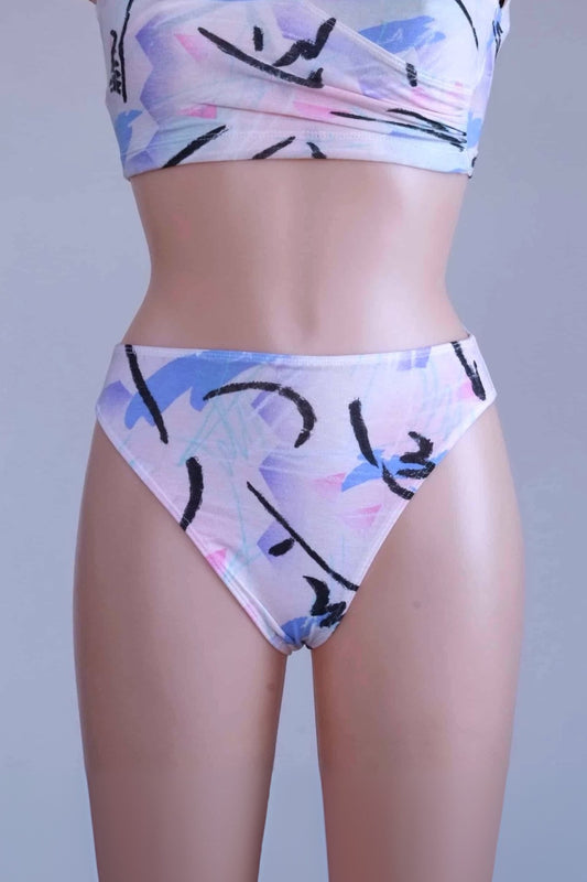 A close-up of a mannequin wearing vintage 90s DANSKIN dance briefs with a white base and blue, purple, and black pastel print.