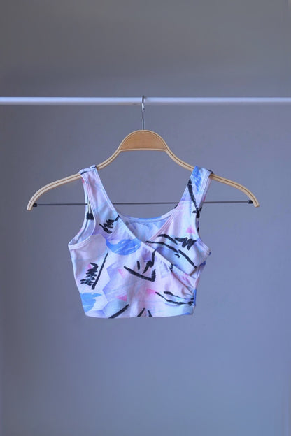 A DANSKIN vintage 90s abstract pastel print crop top, displayed on a hanger.