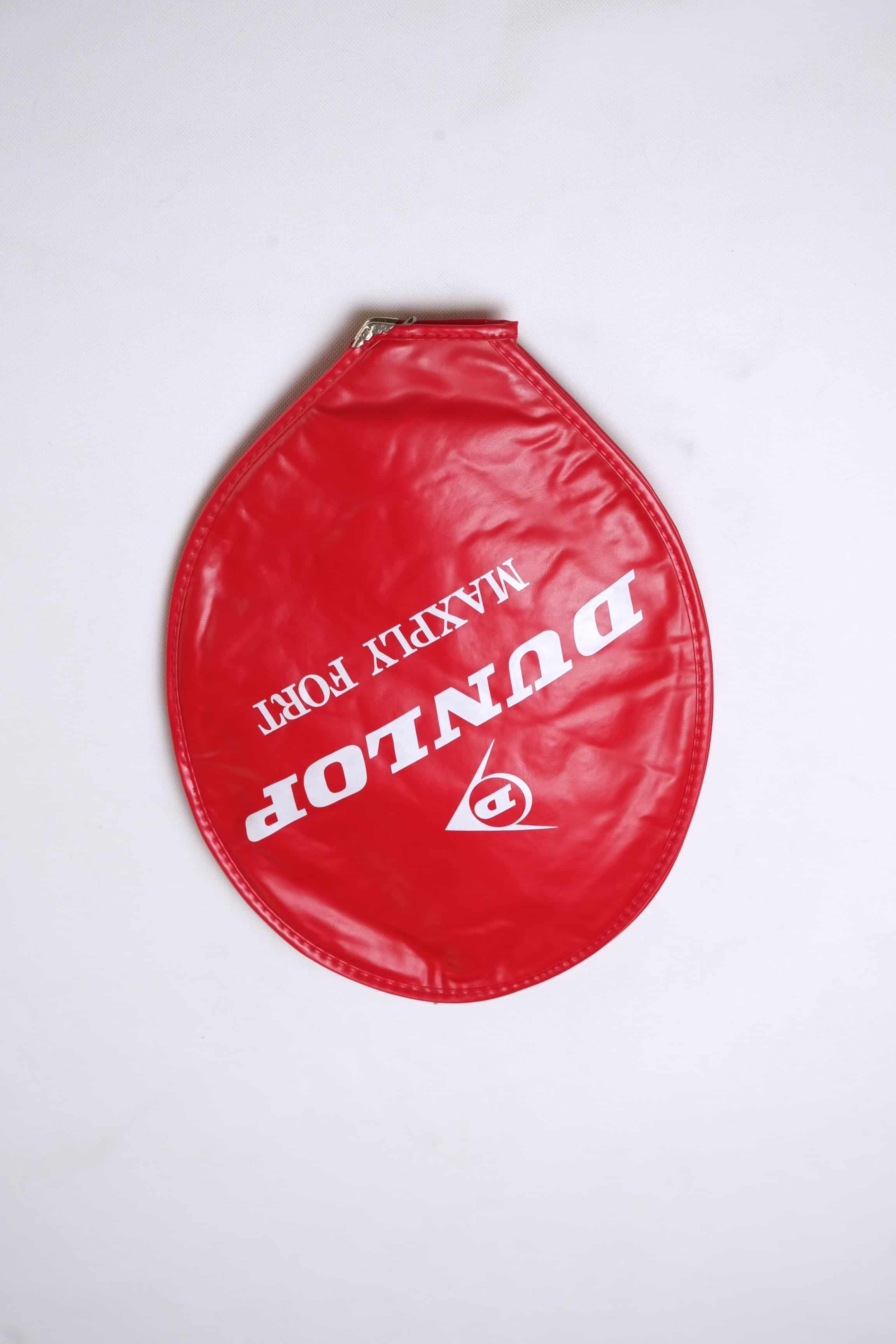 Red vintage vinyl Dunlop Maxply Fort tennis racket head cover with white branding and zipper enclosure, isolated on a white background.