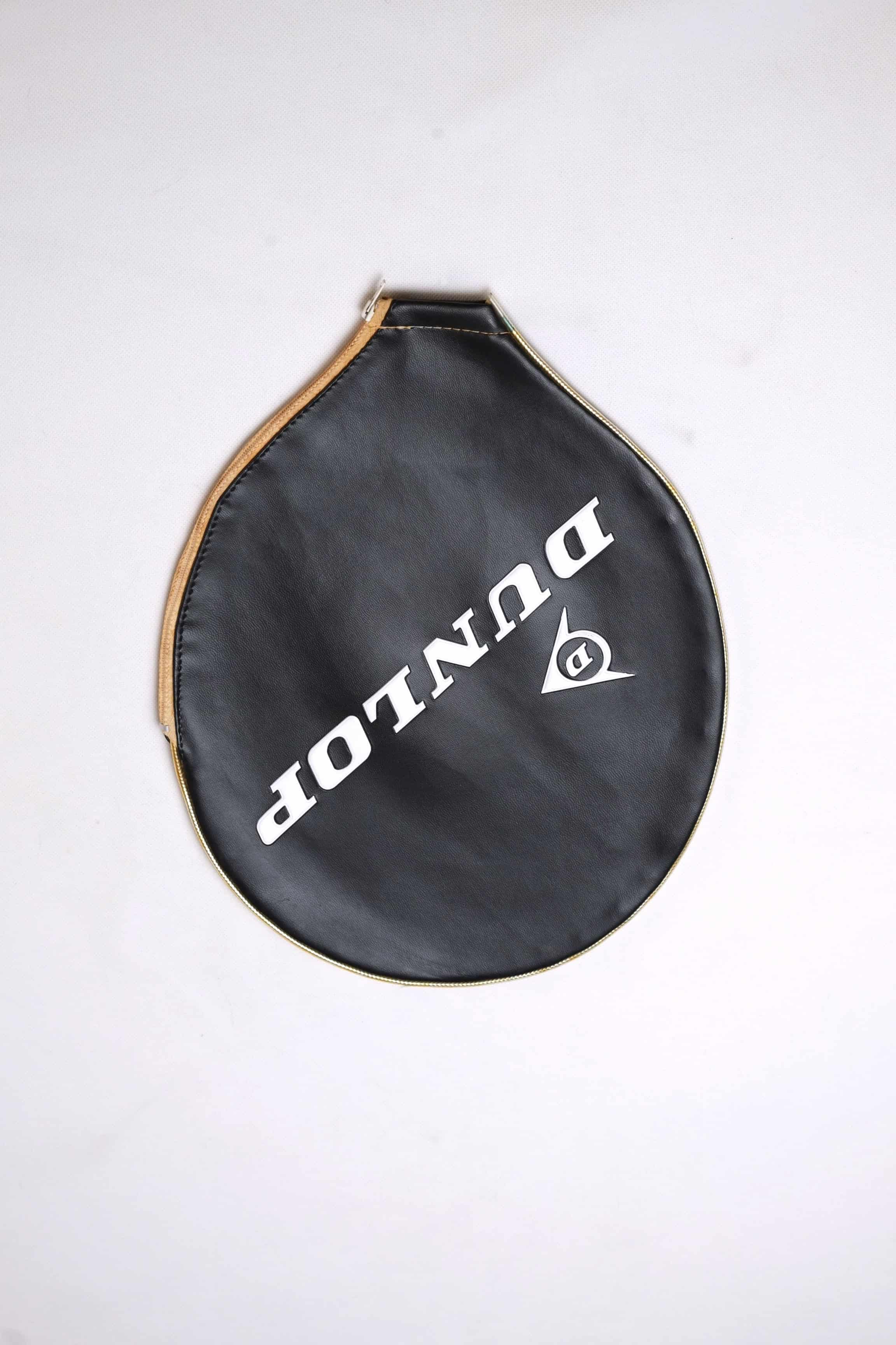 Vintage black vinyl Dunlop tennis racket zippered head cover with diagonal white branding, shown on a clean white backdrop.