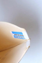 Interior detail of a vintage white vinyl Dunlop tennis racket cover showing the original blue and white "DUNLOP Made in England" cloth tag.