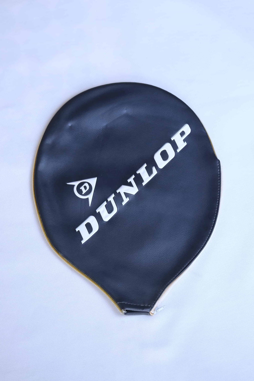 Vintage navy vinyl Dunlop tennis racket zippered head cover with diagonal white branding, shown on a clean white backdrop.